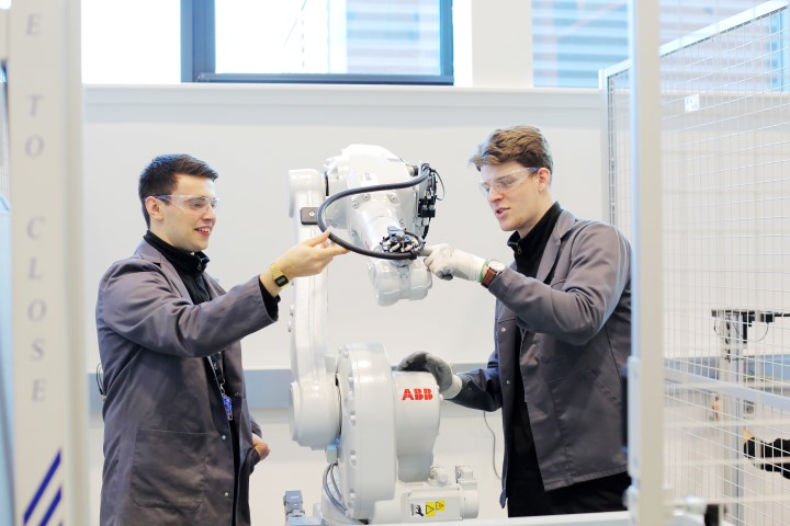 Two engineers using a robotic arm in a laboratory.