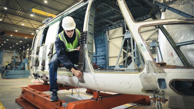 Person working on helicopter chassis